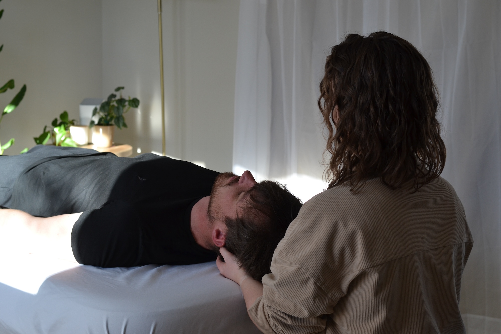 Certified Rolfer holding the head of a client