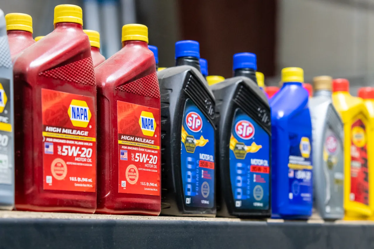 Engine oil products including NAPA and STP 5W-20 lined up on a shop shelf for heavy-duty maintenance.