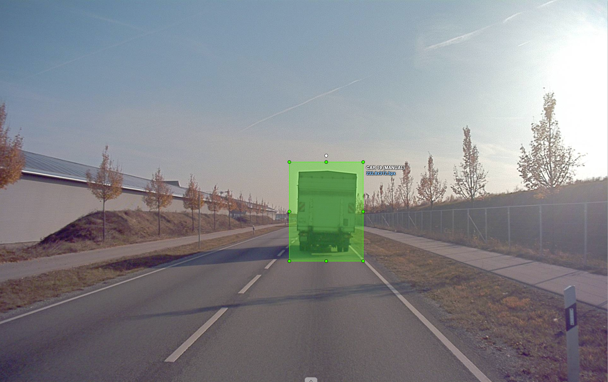 A view of a highway. The perception system highlights the truck in green.