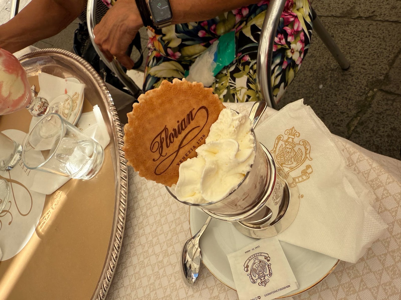A hot chocolate with whipped cream and a cookie that says Florian Venezia