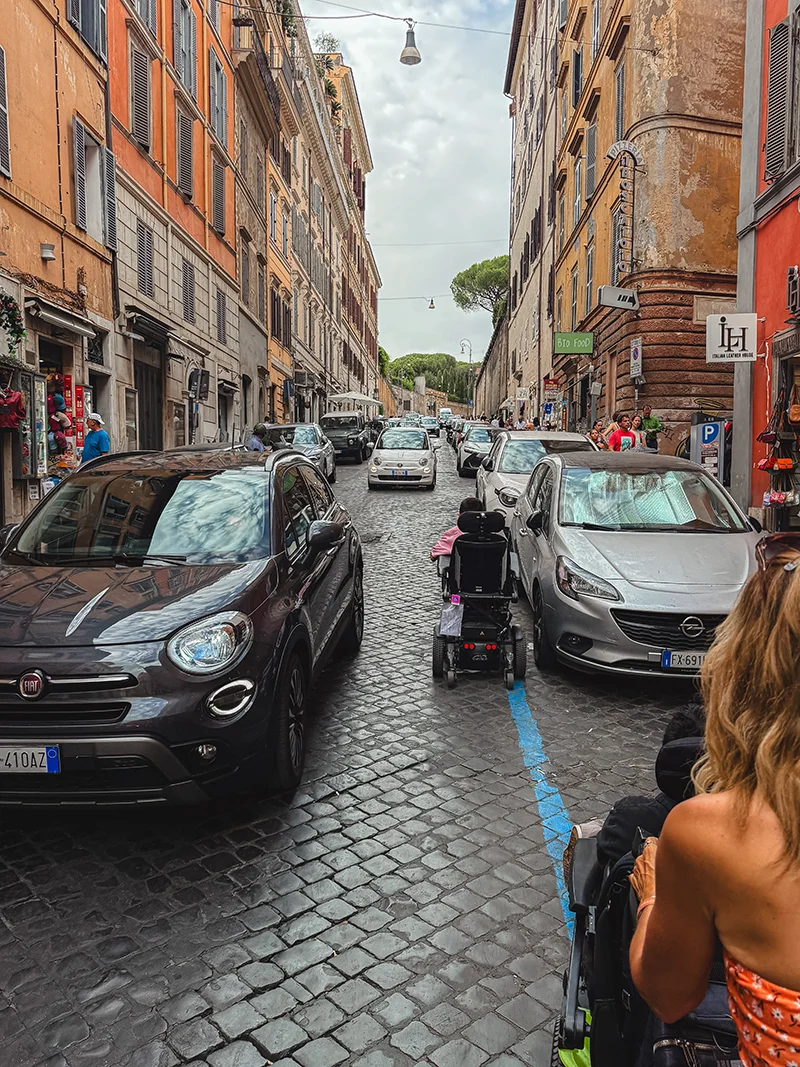 A wheelchair user traveling uphill on cobblestone street