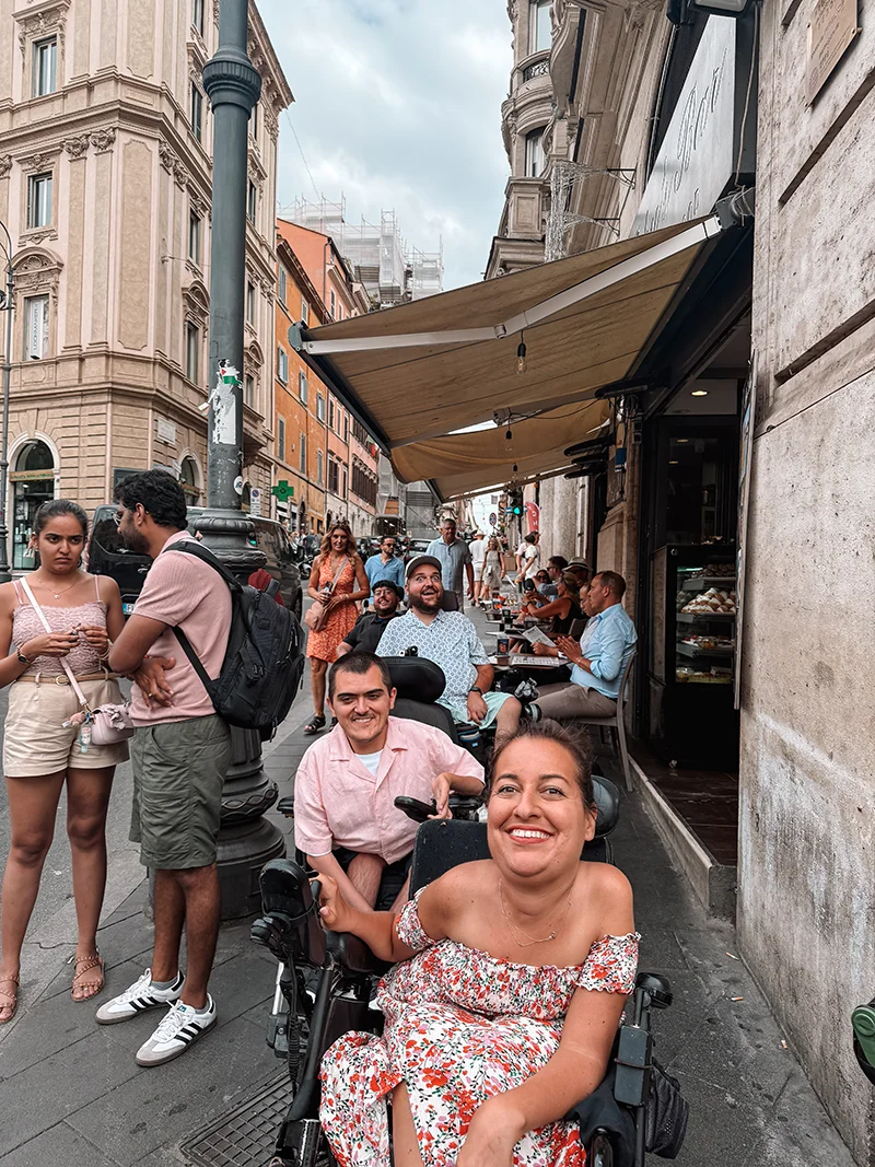 A line of people smiling for the camera on a sidewalk
