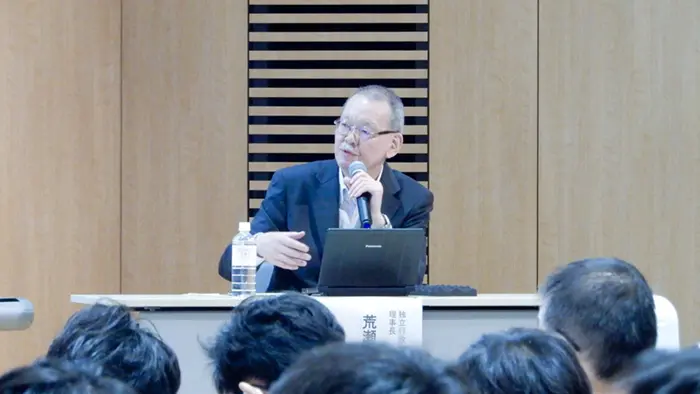 会場で参加者からの質問に答える荒瀬理事長