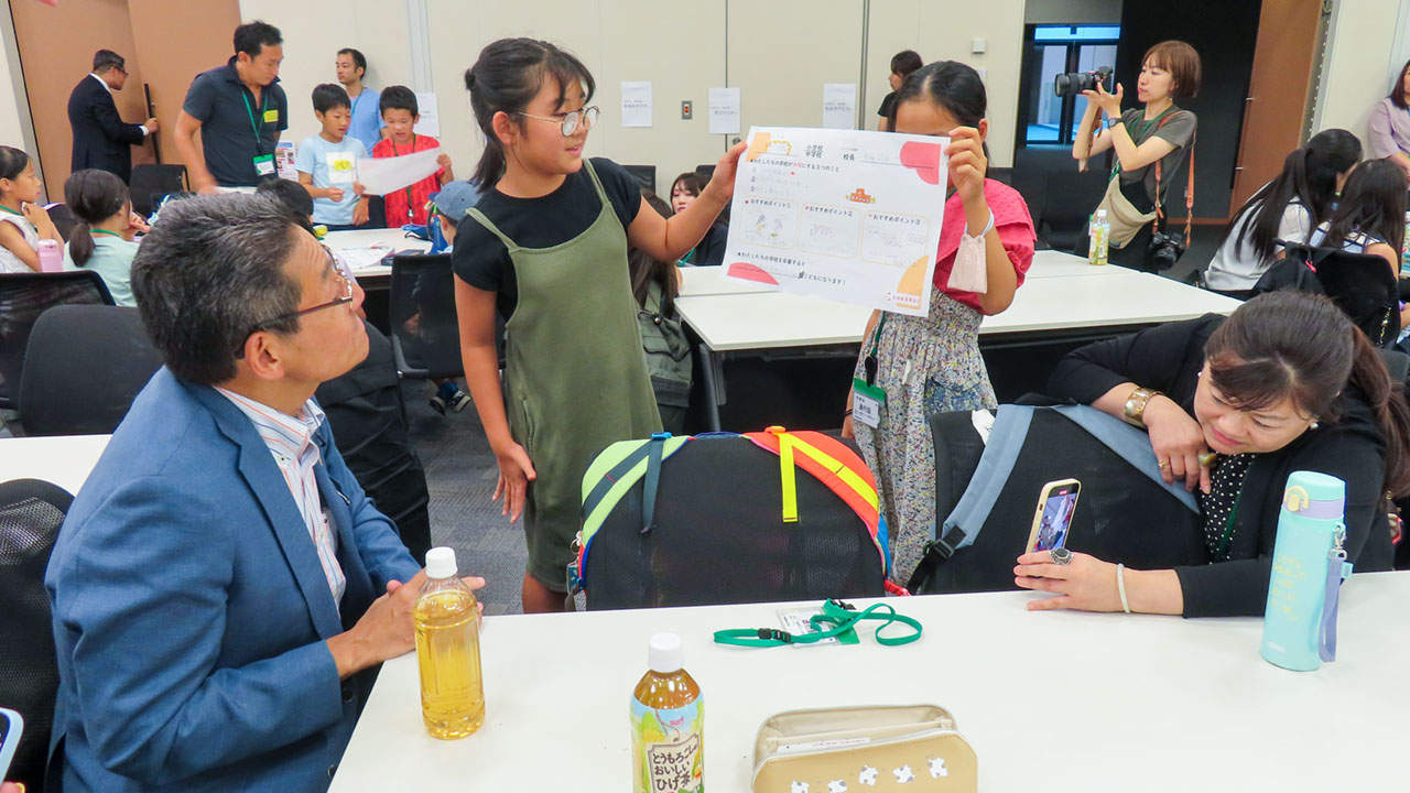 子どもたちのプレゼンテーションに耳を傾ける国会議員ら