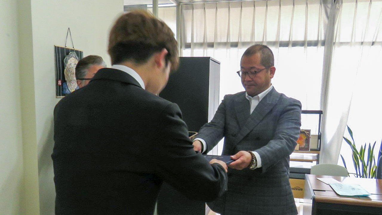 人見教頭（右）から卒業証書を受け取る大塚さん（仮名）・RITA学園高校提供