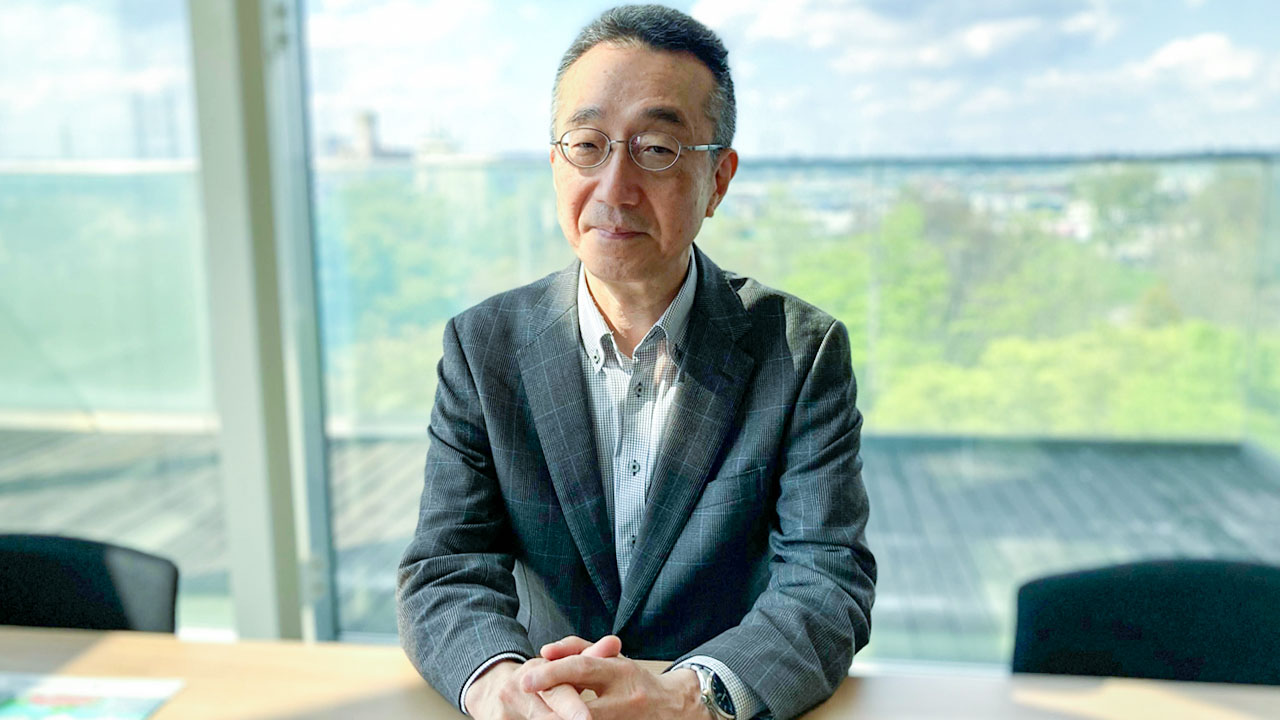 スピーキング試験導入の経緯を説明する同学の青山副学長