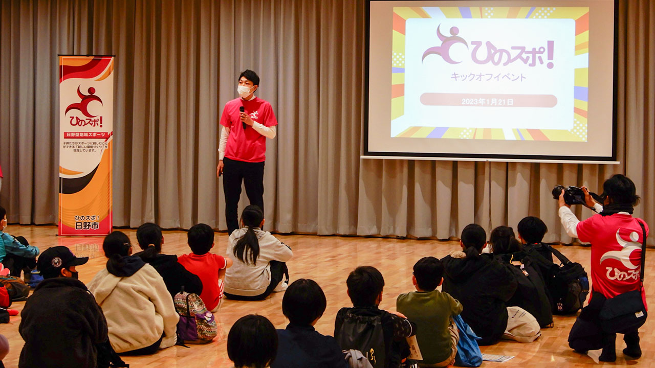 子どもたちを前に、「ひのスポ」について説明する堀川教育長