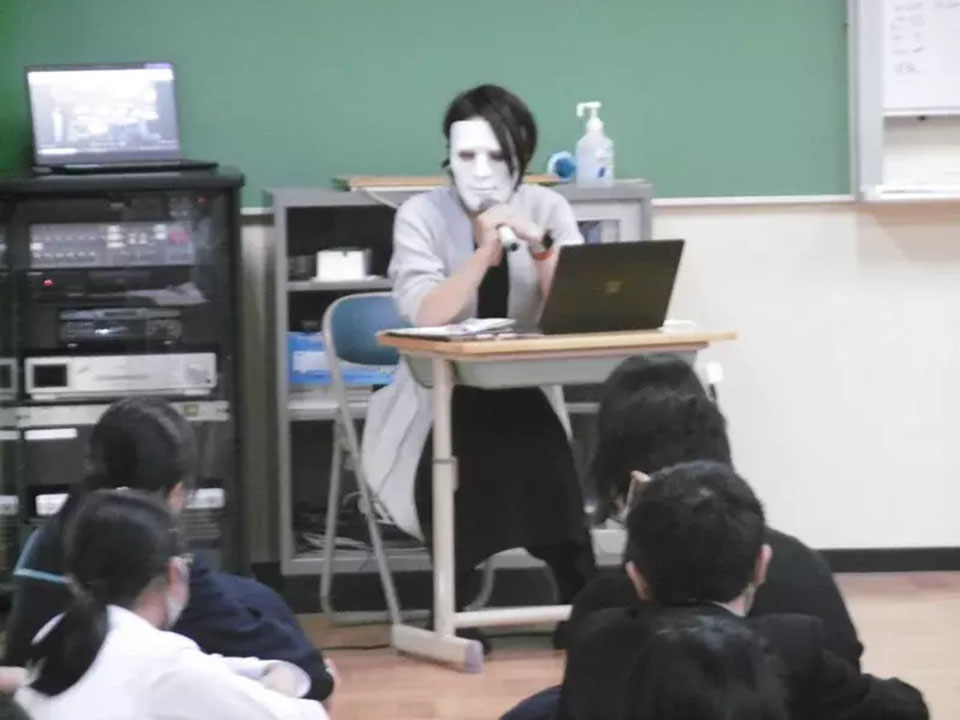 中学校のキャリア教育の授業に仮面姿で登場した尾崎さん