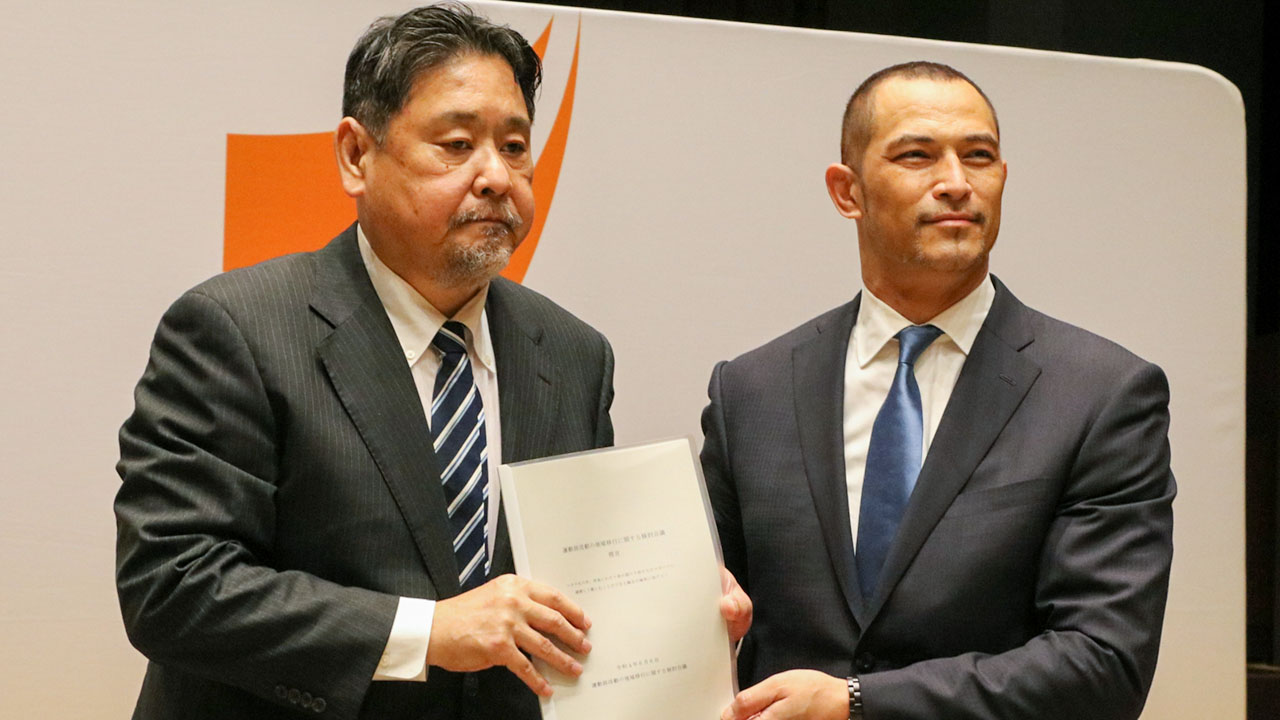  運動部活動の地域移行に関する提言を検討会議の友添座長（左）から受け取った室伏スポーツ庁長官