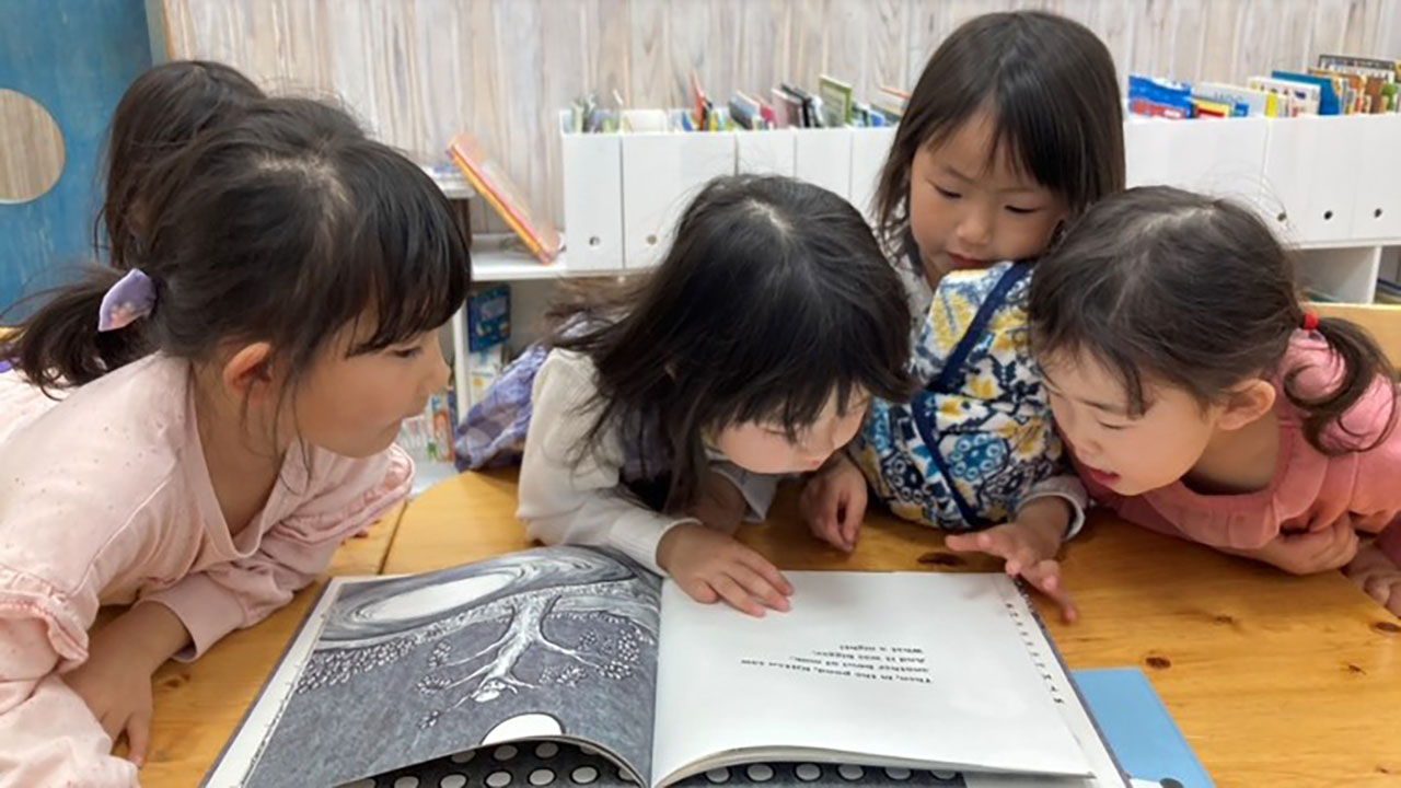 園で何度も読んだ絵本を、今度は子供たちだけで読もうとしている（澤さん提供）