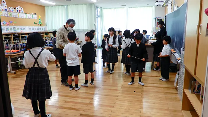 地域の人から冬の遊びを学ぶ1・2年生＝撮影：秦さわみ