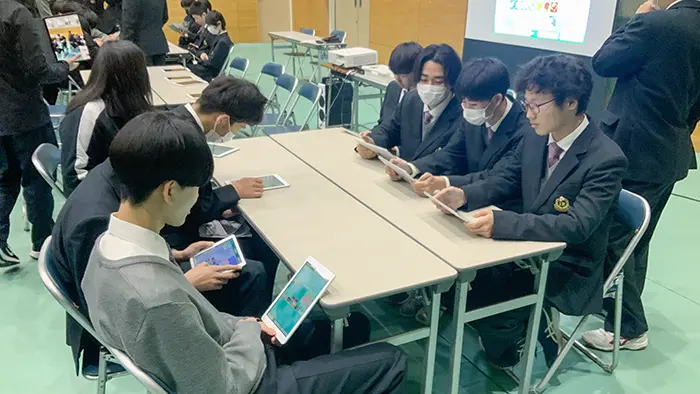 iPadゲーム「ゴッドフィールド」に取り組む生徒ら＝提供:広島桜が丘高校