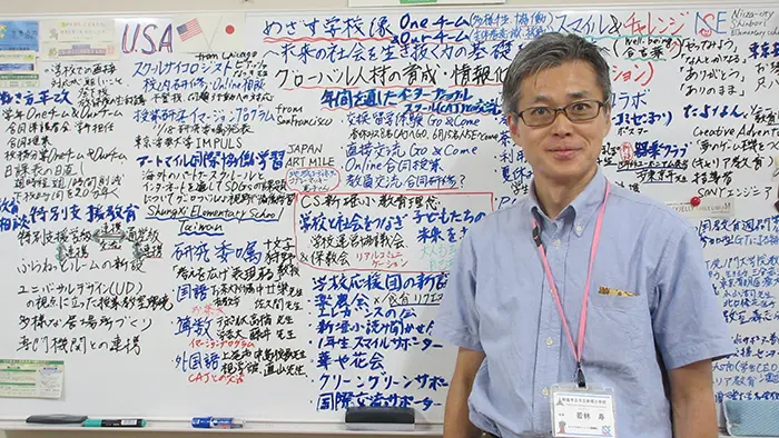 校長室のホワイトボードに、インターナショナルスクールとの交流など主要な企画を書き出している若林校長＝撮影：川嶋千恵