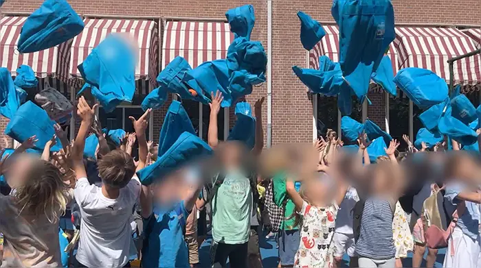 夏休みの始まりにカバンを投げる子どもたち＝筆者提供