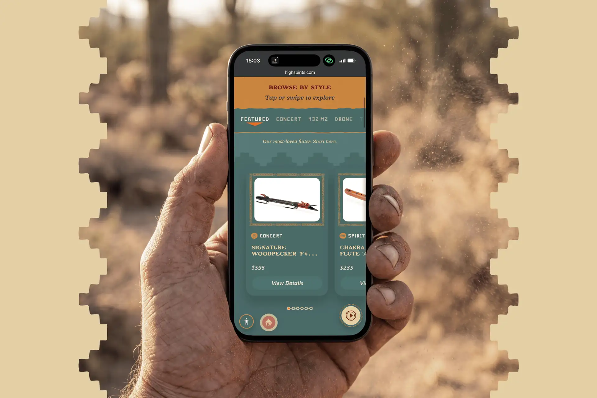 A weathered hand holds a smartphone showing the redesigned High Spirits Flutes mobile store, its Browse by Style flute carousel open, against the sunlit Sonoran desert.