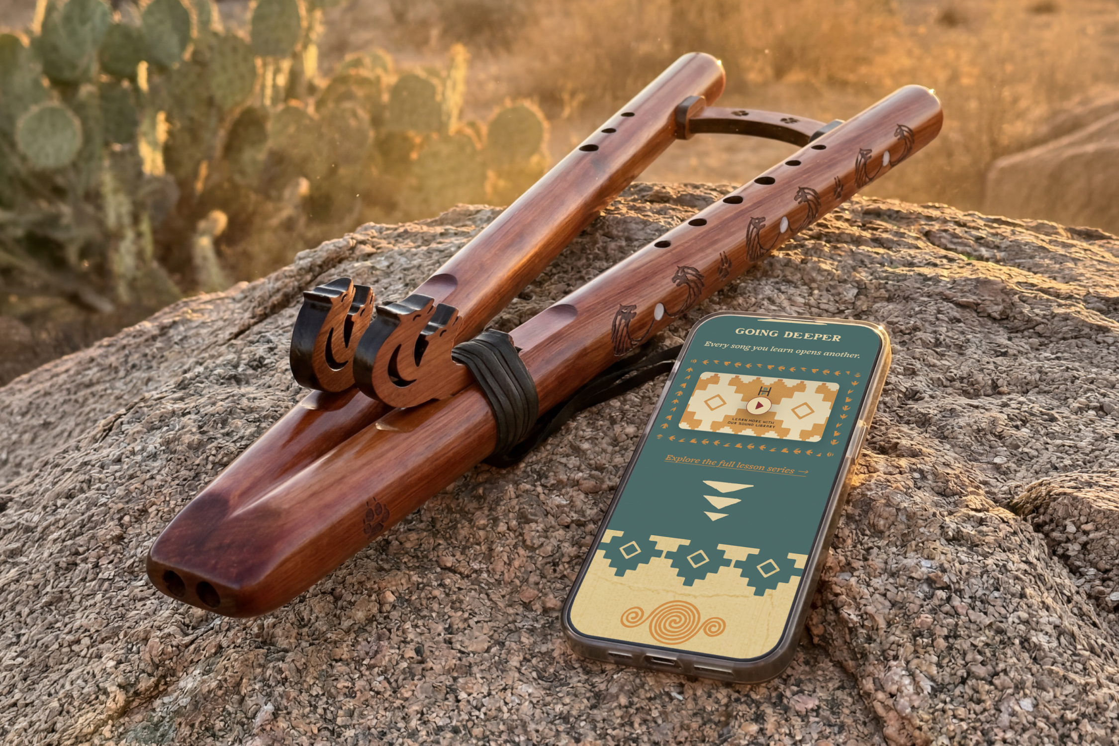 Handcrafted High Spirits flute resting on sunlit desert stone beside a smartphone showing the brand's redesigned mobile site.