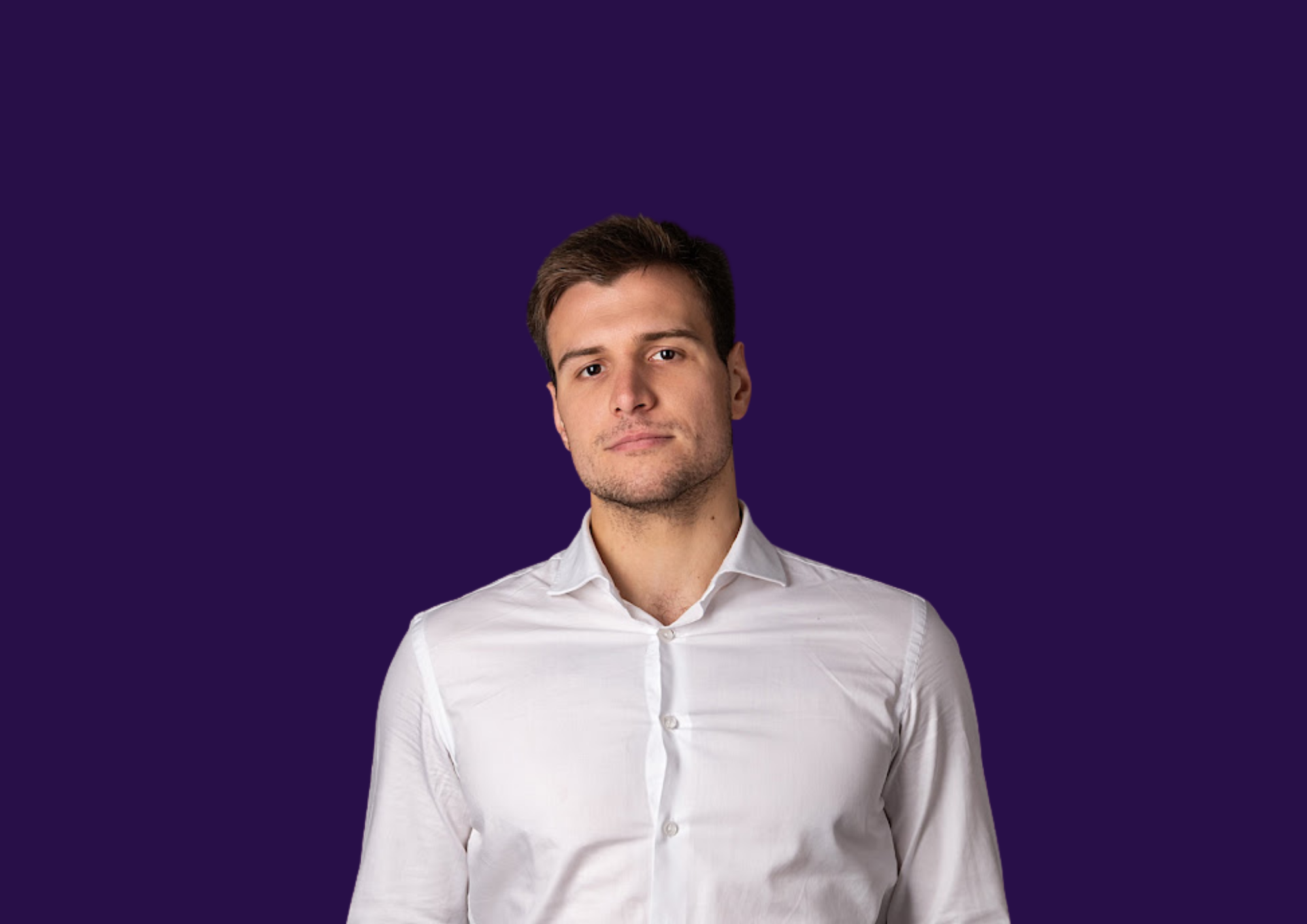 Mężczyzna w białej koszuli na fioletowym tle, patrzący prosto w kamerę.