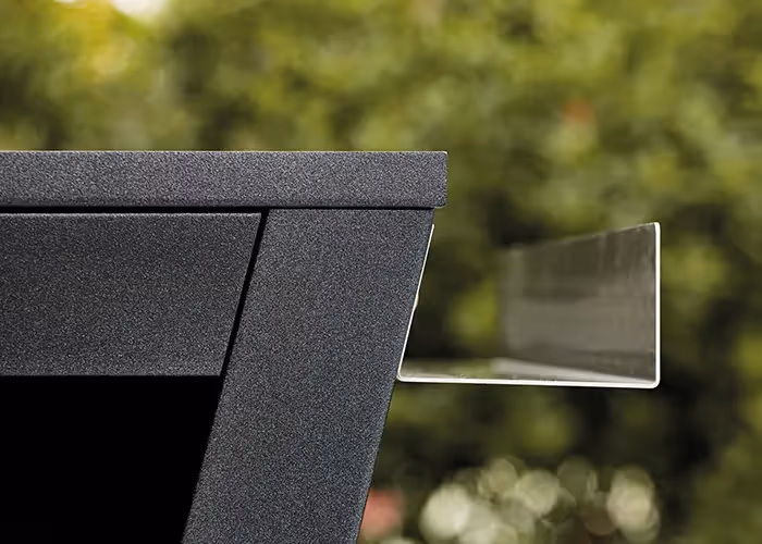 Dettaglio ravvicinato di un supporto laterale in acciaio integrato in un barbecue moderno da esterno con struttura in metallo nero.