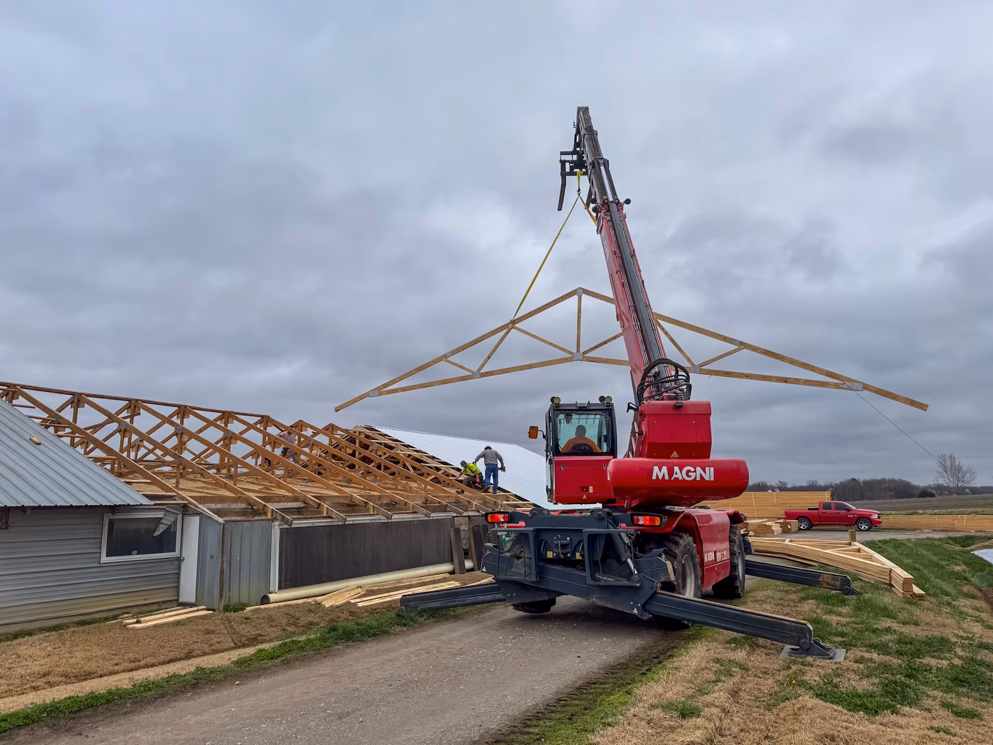 Trusses being lifted by our Magni telehandler while building barns