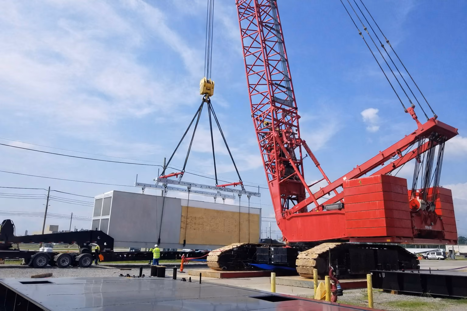 A crane lifting concrete with spreader bars