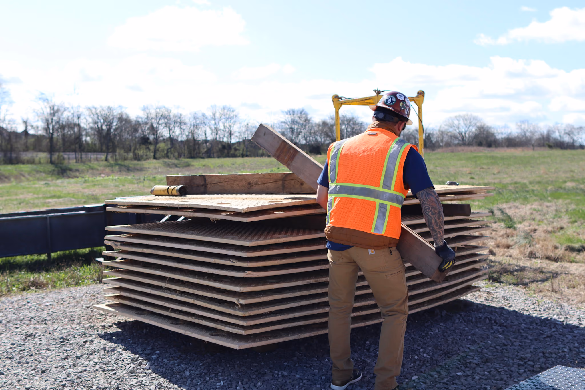 A TSR employee stacking composite ground protection mats