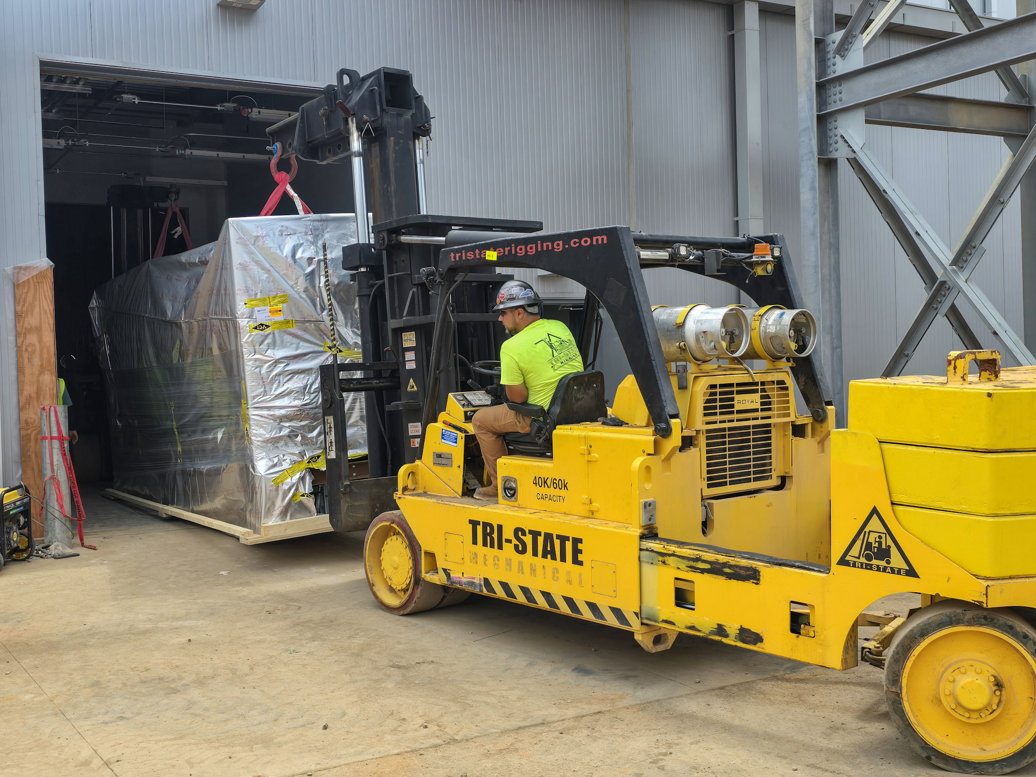 Tri-State Rigging using a forklift to move equipment into a facility