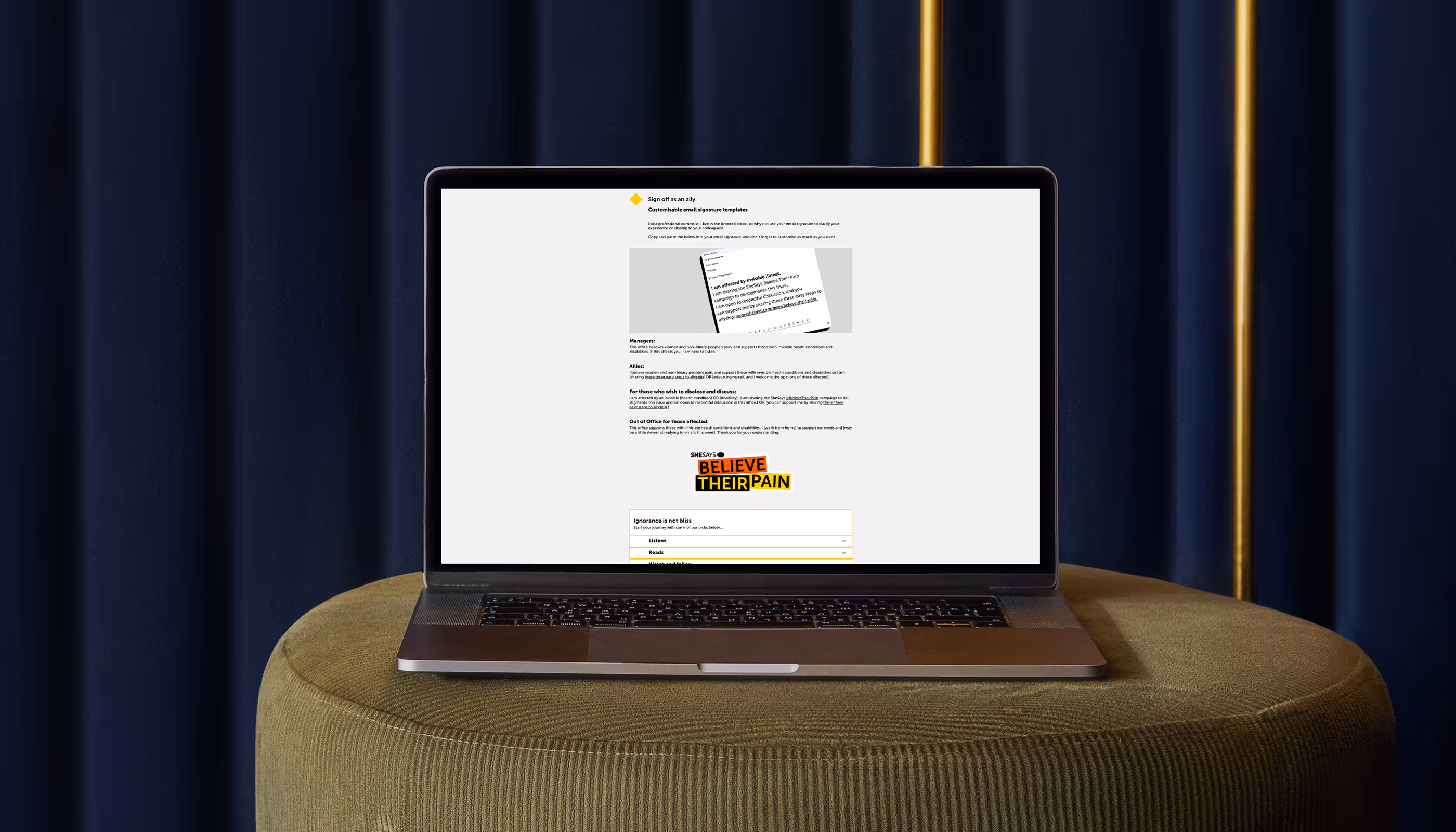BelieveTheirSite website as shown on a Macbook. The laptop sits on a green chair, in front of a blue velvet curtain