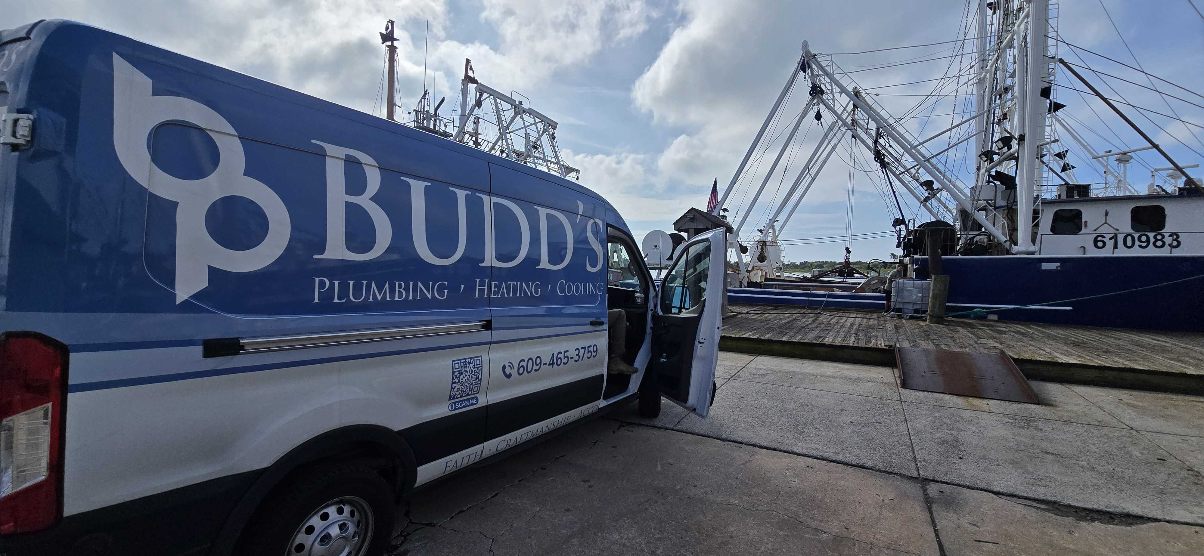 A truck parked next to a fishing boat at a dock.