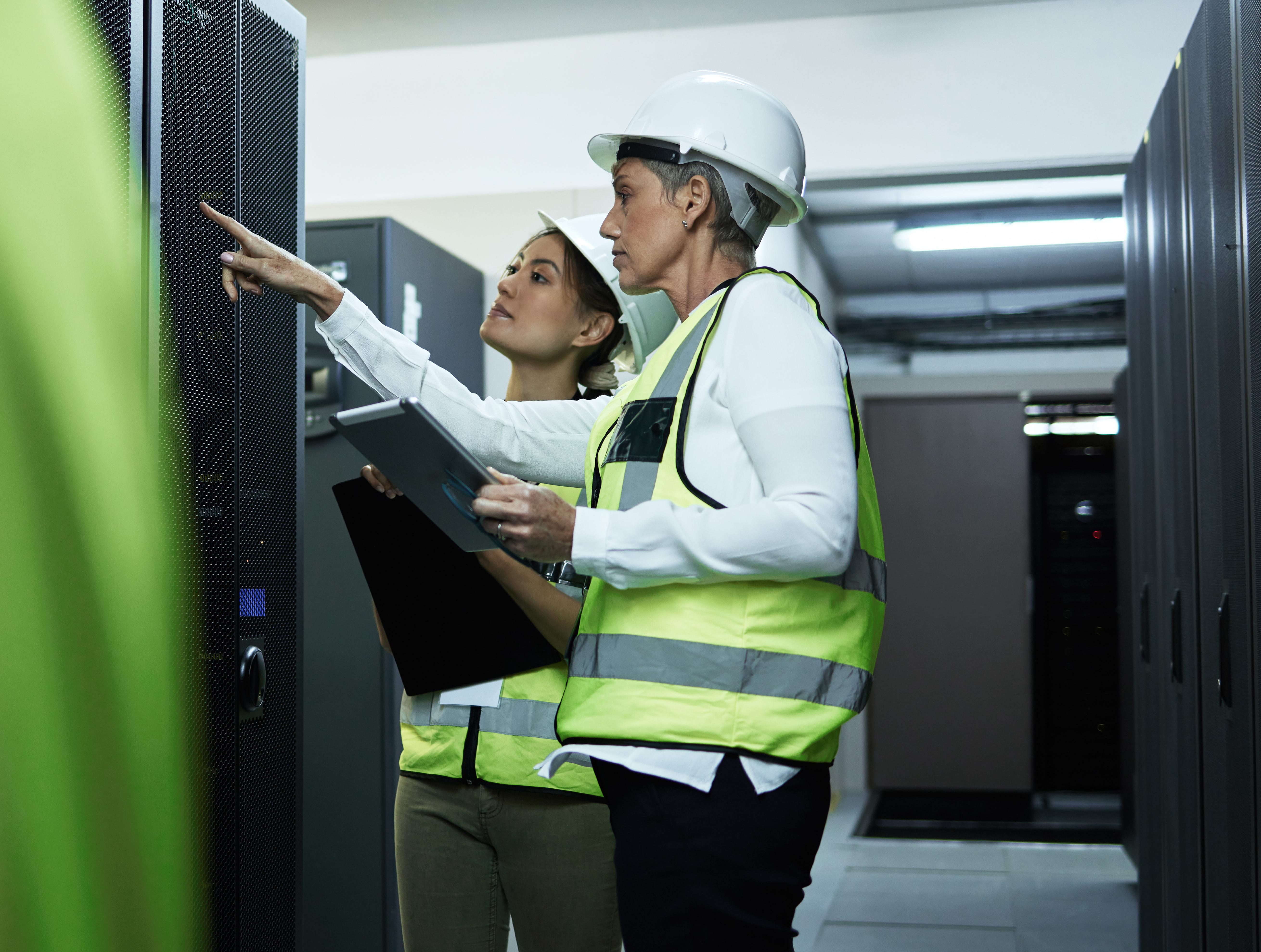 Two engineers monitoring and inspecting server towers as part of ITAD services in Singapore