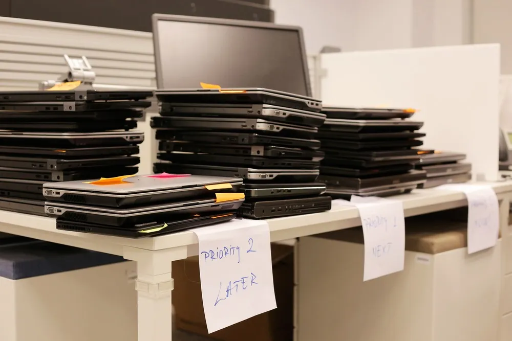 Stacks of retired laptops organised for laptop recycling services in Singapore