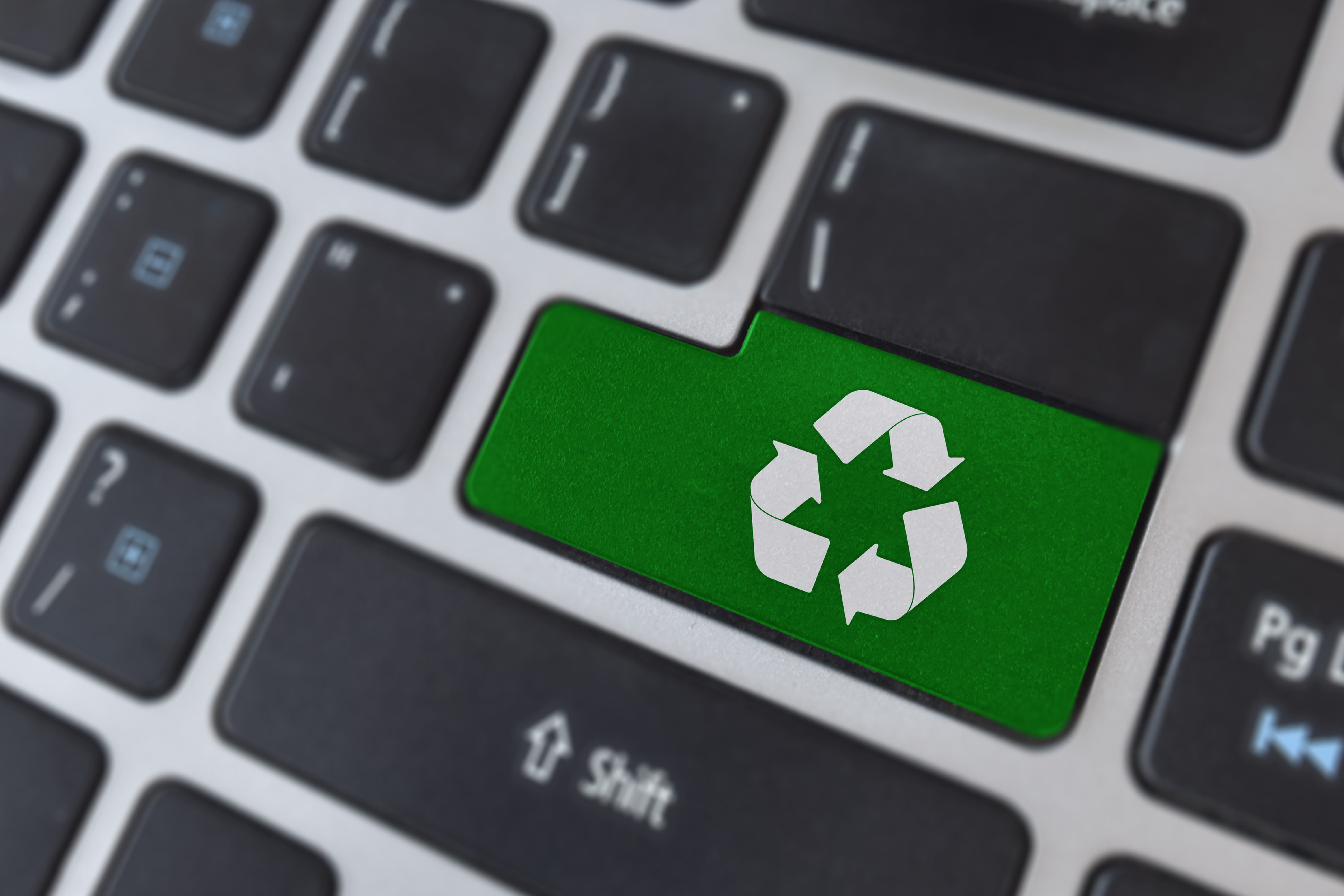 Recycling symbol on computer keyboard representing an e-waste recycling company in Singapore