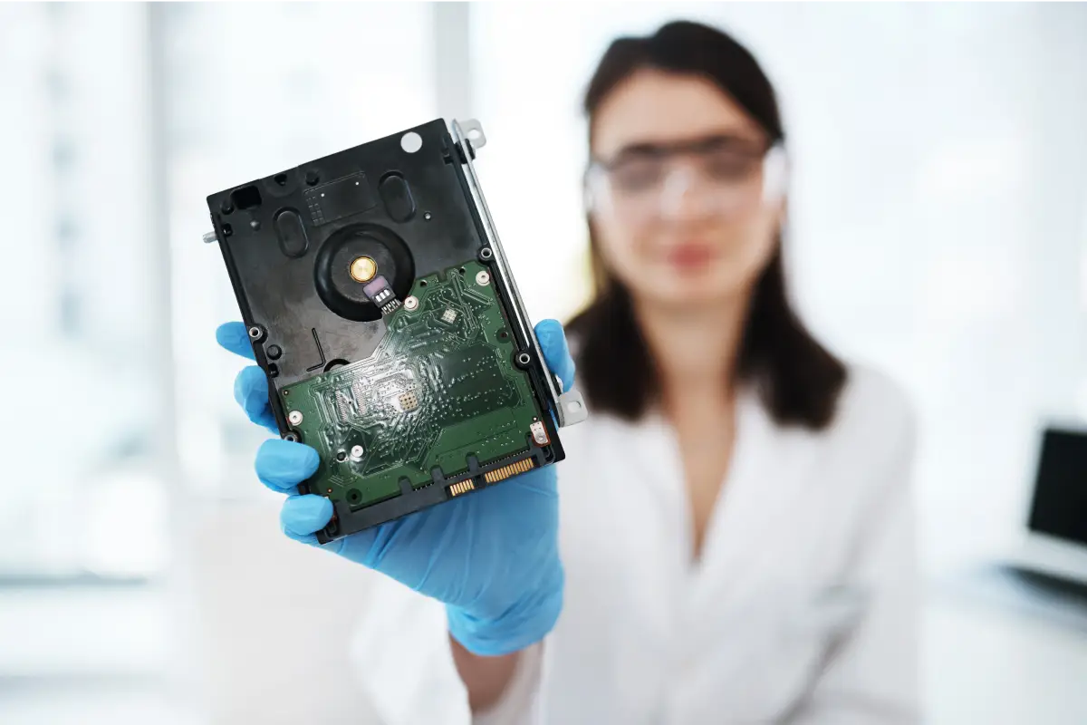 a staff of an e-waste recycling company in Singapore holding a hard drive for secure data destruction