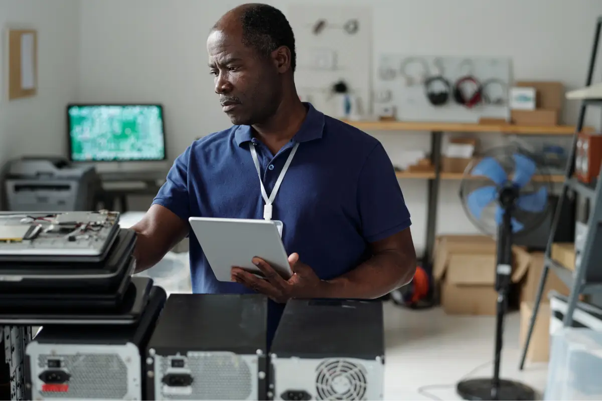 Technician tracking retired laptops for secure recycling and asset reporting in Singapore
