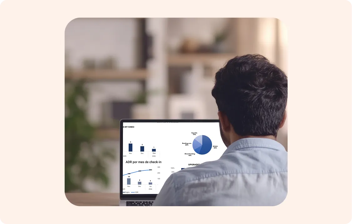 Man in blue shirt looking at a laptop screen with charts and graphs on data analysis.