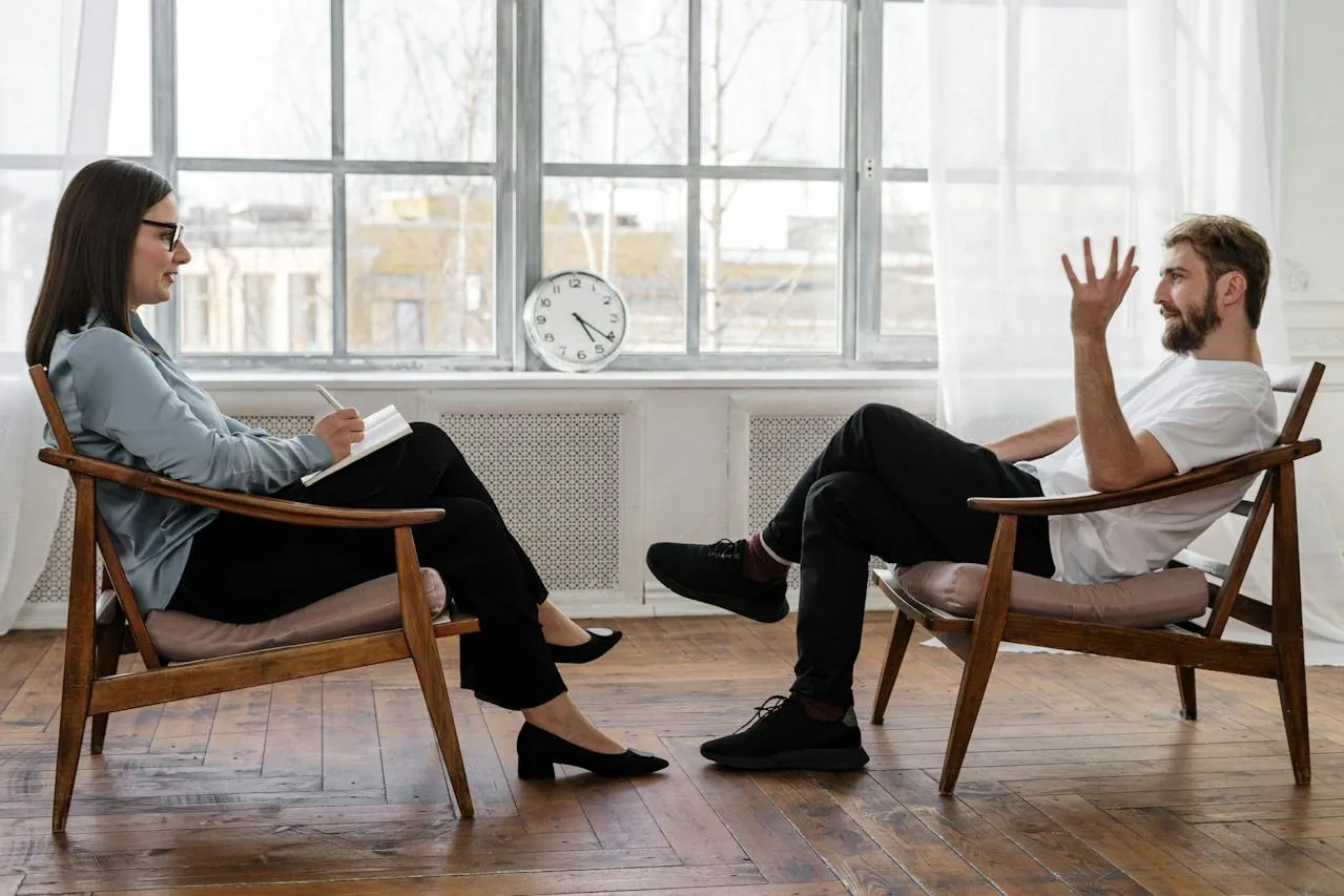 Man and women sitting on chairs facing eachother