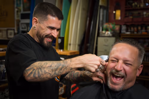 A cinematic image of a barber cutting hair