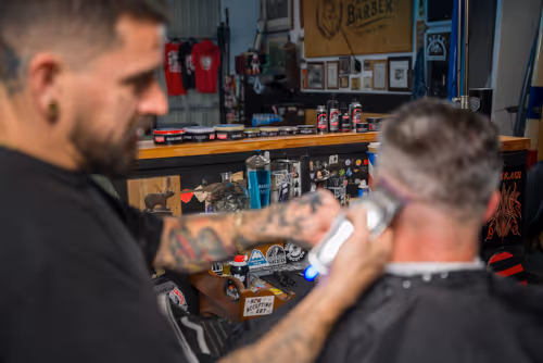A cinematic image of a barber cutting hair