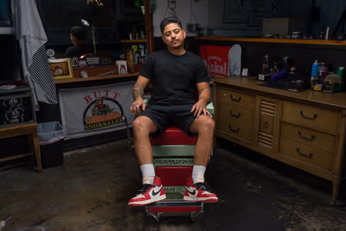 A cinematic image of a barber in his barber chair from their website we designed and developed