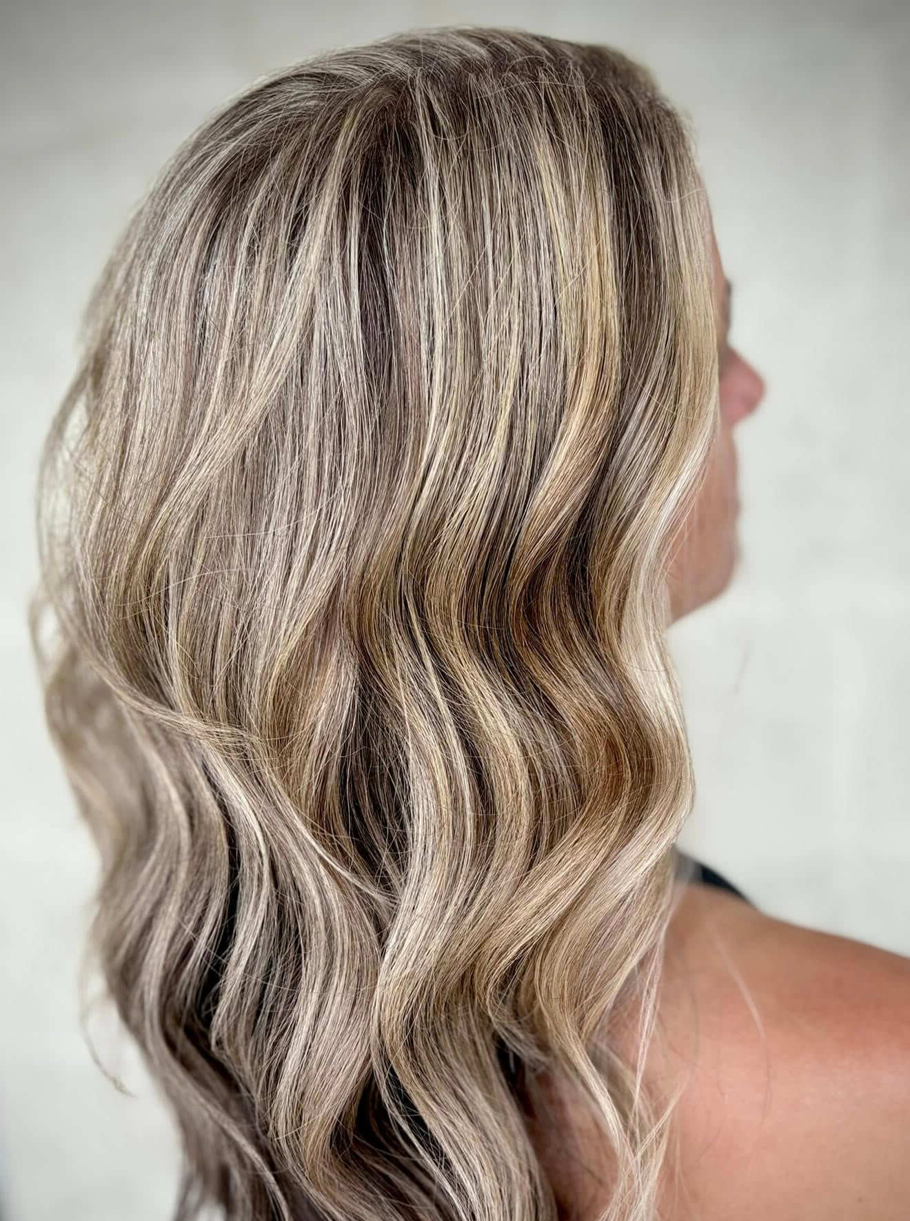 Close-up of long, wavy hair with blonde and light brown highlights.