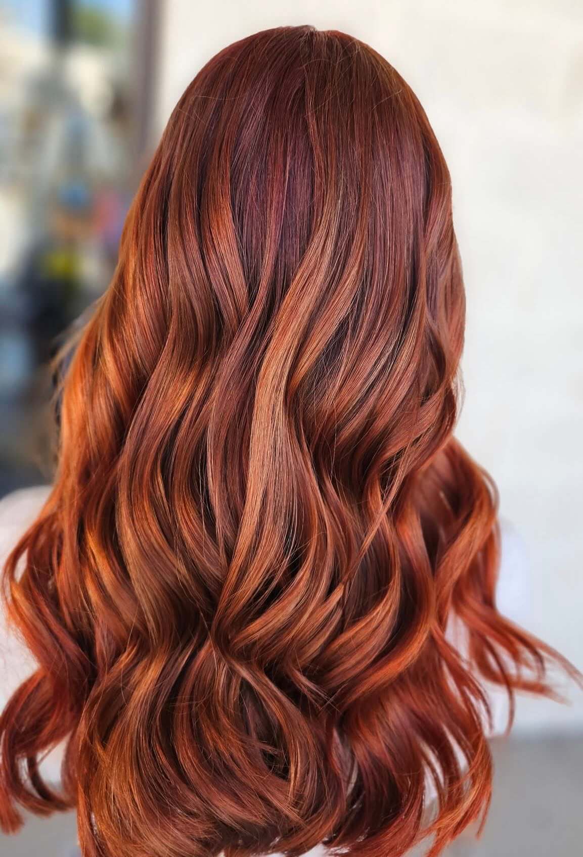 Back view of long, wavy hair with rich red and copper tones.