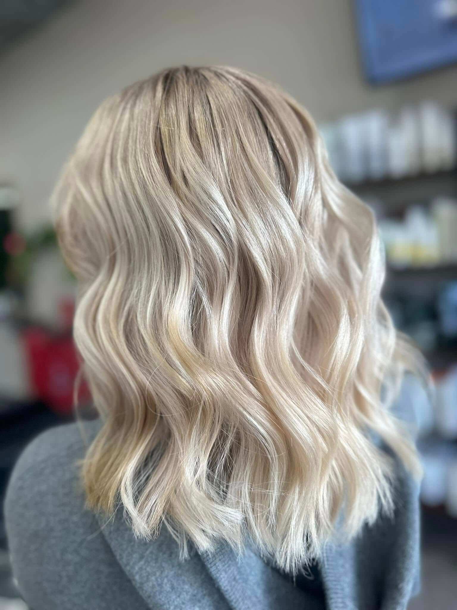 Back view of medium-length wavy blonde hair with subtle, lived in highlights.