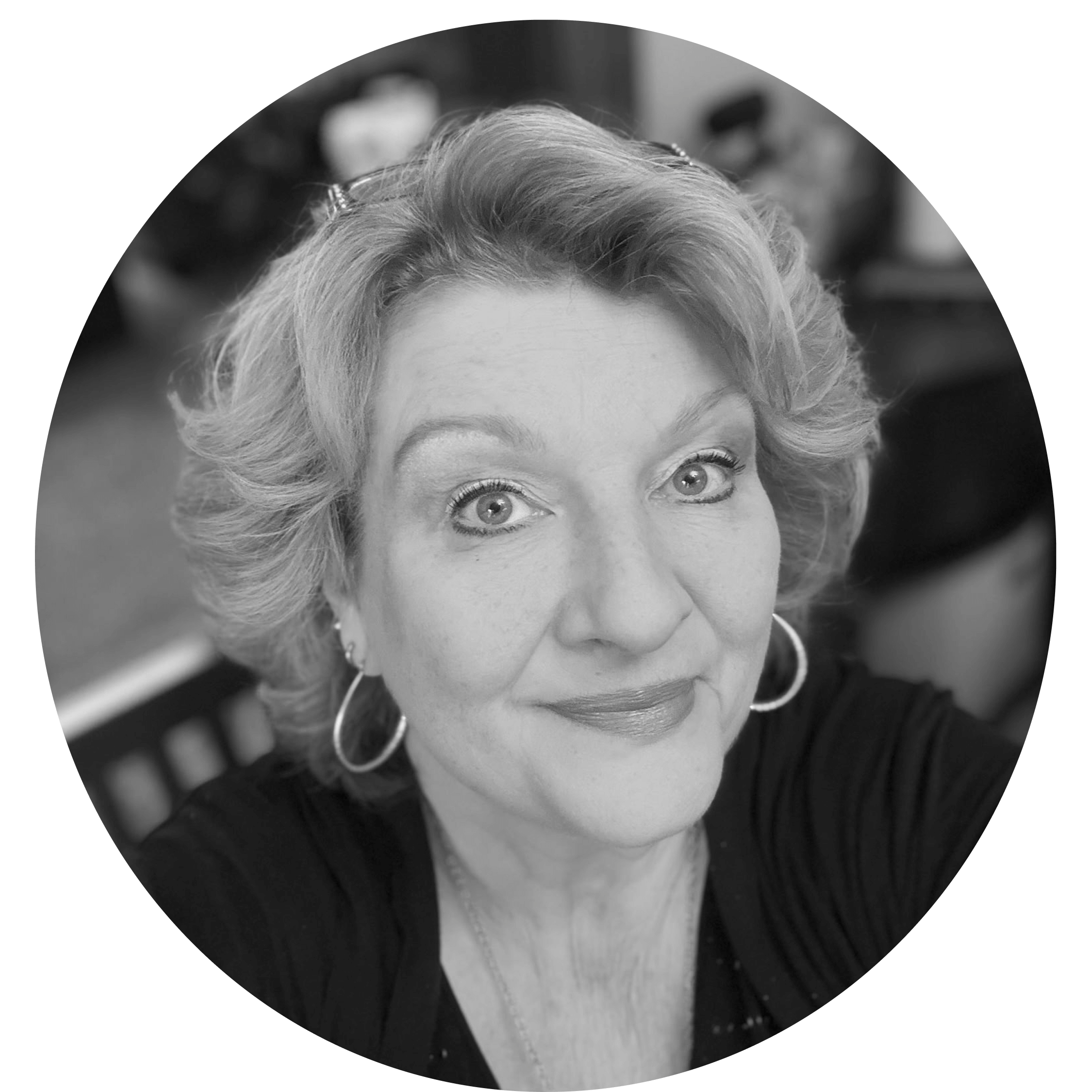 Close-up black and white portrait of a smiling woman with short wavy hair and hoop earrings.