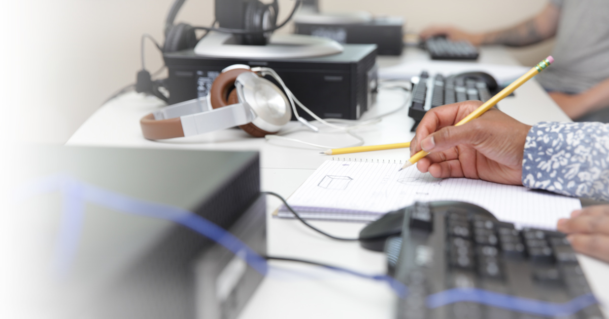 Photo of student writing in front of computer