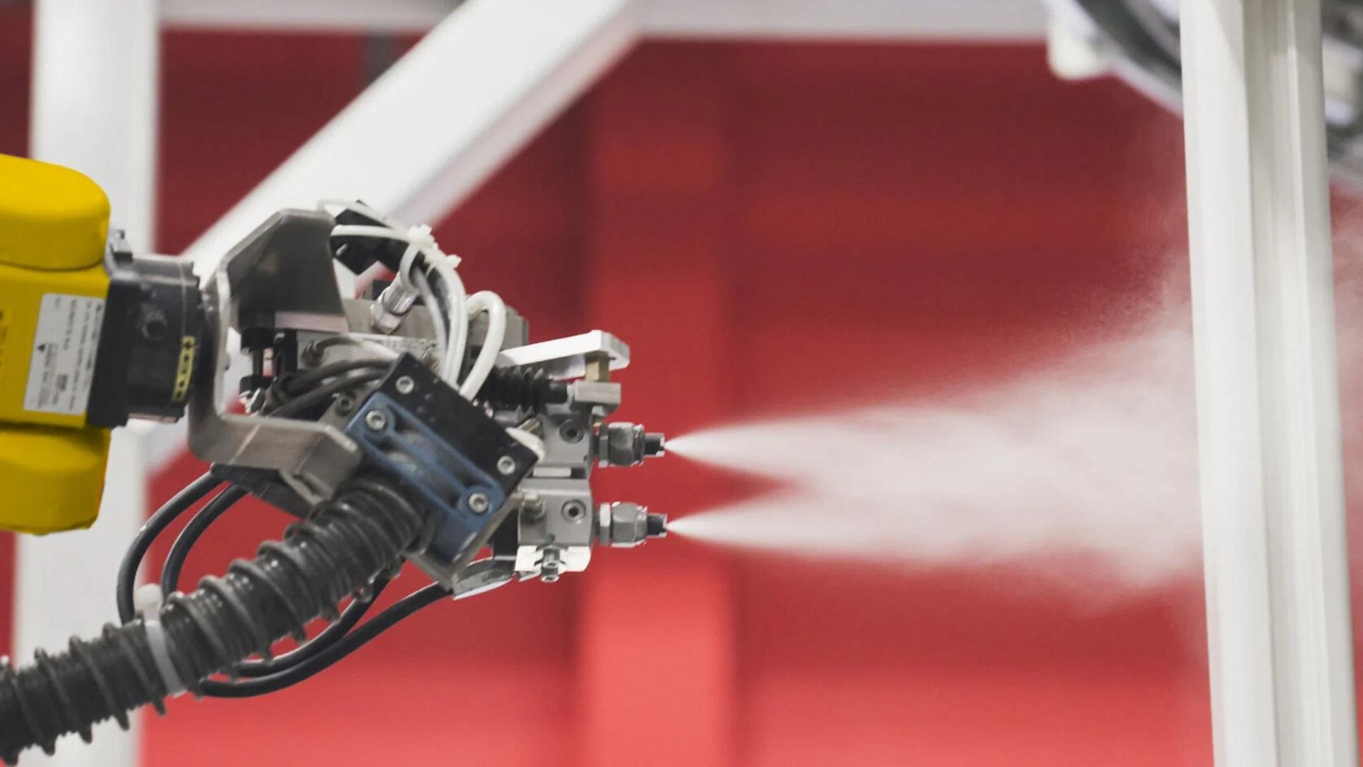Robotic spray nozzles atomising a coating
