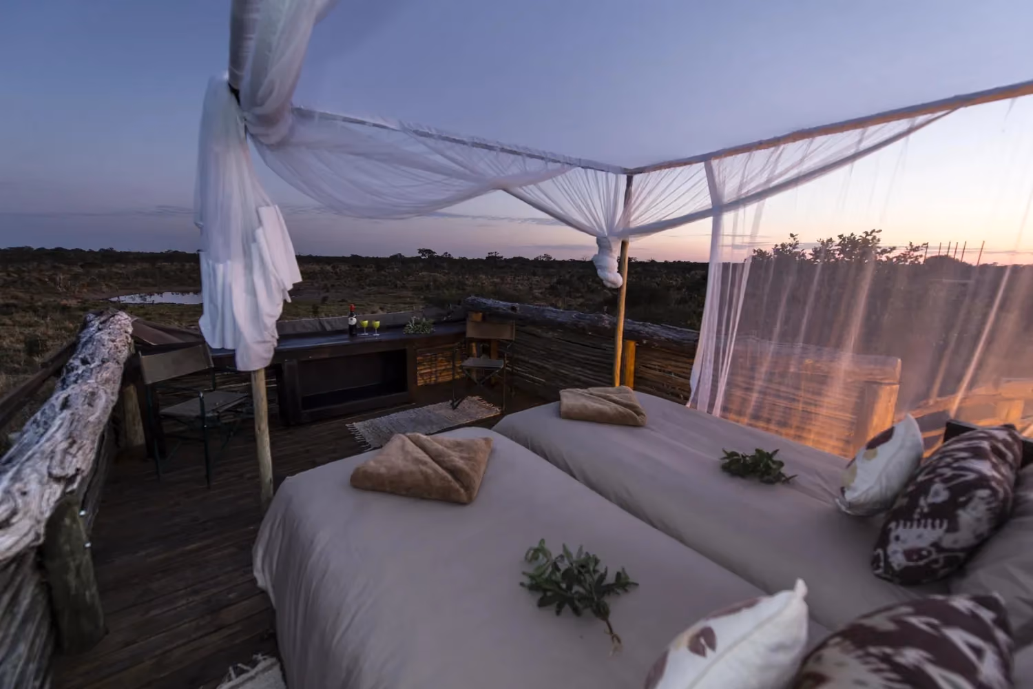 Rooftop view of a treehouse in Africa with bed and waterhole