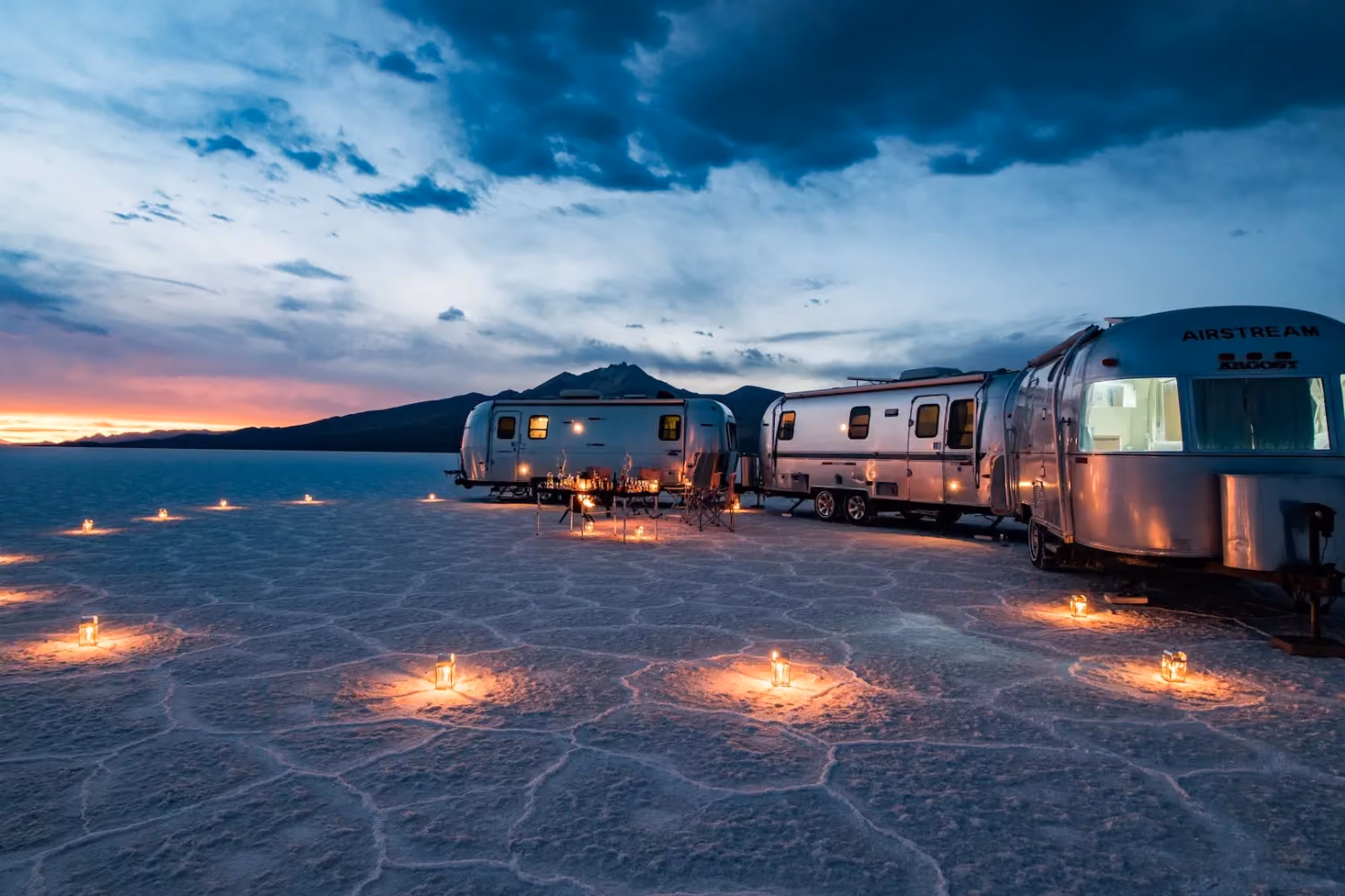Two airstream trailers side by side on a salt pan