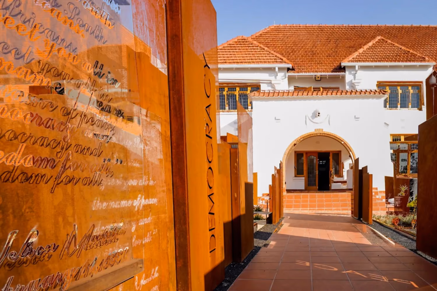 Exterior of terracotta roofed house with writting on walls nearby