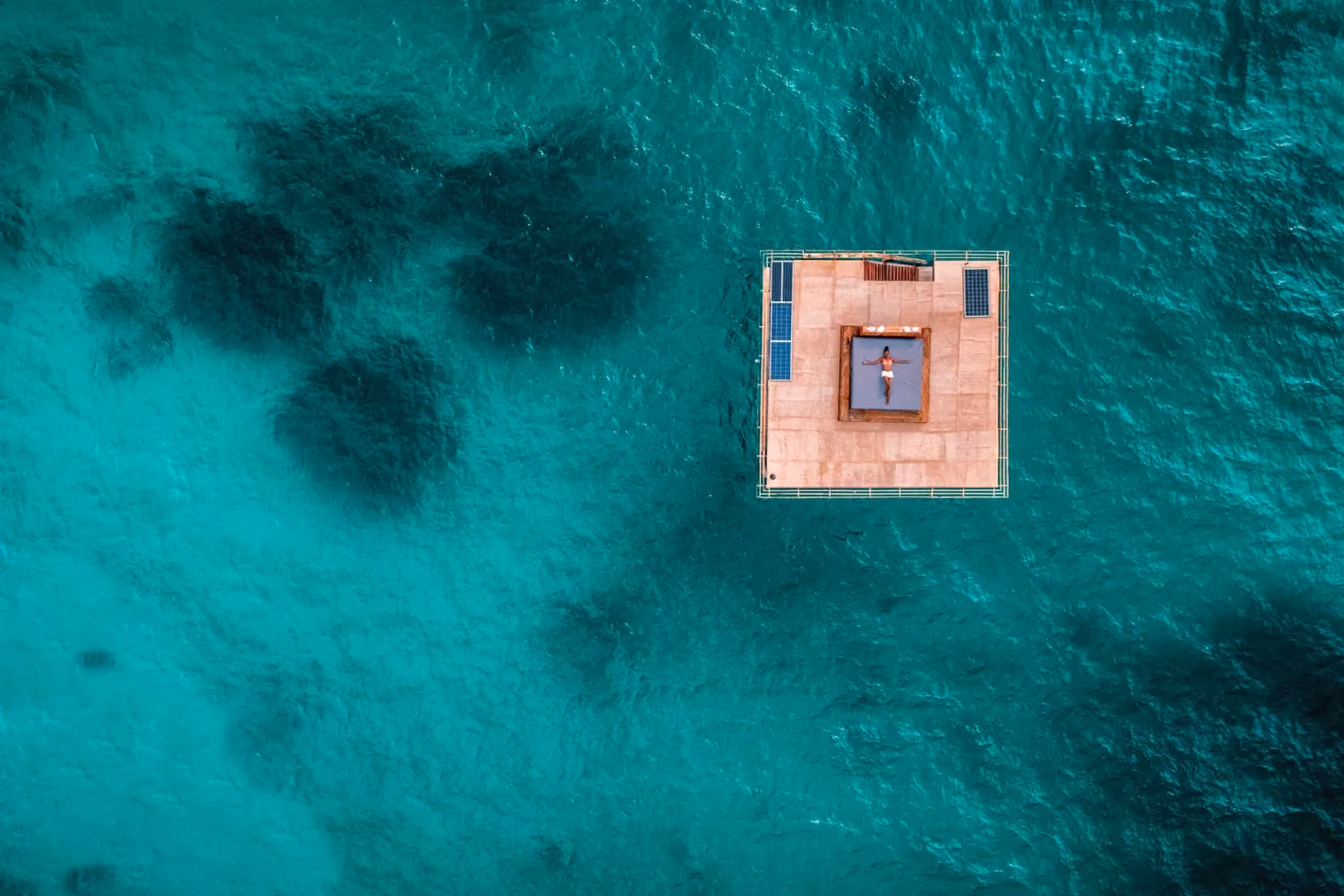 Aerial view of a floating room with woman lying on day bed