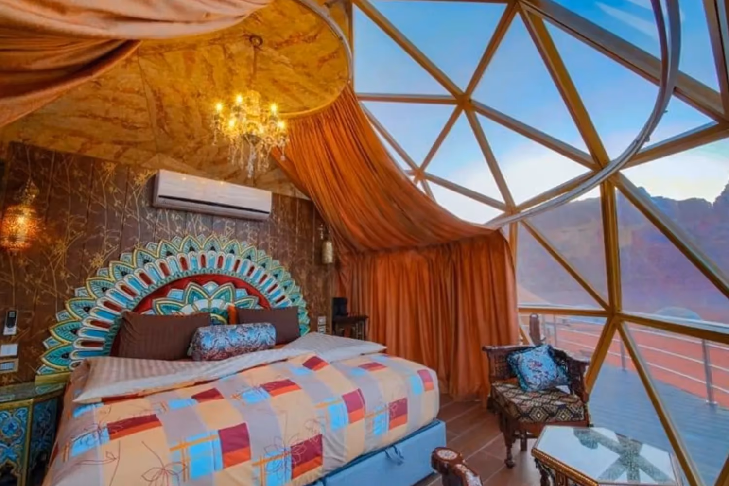 Brightly coloured room inside a bubble structure with desert outside