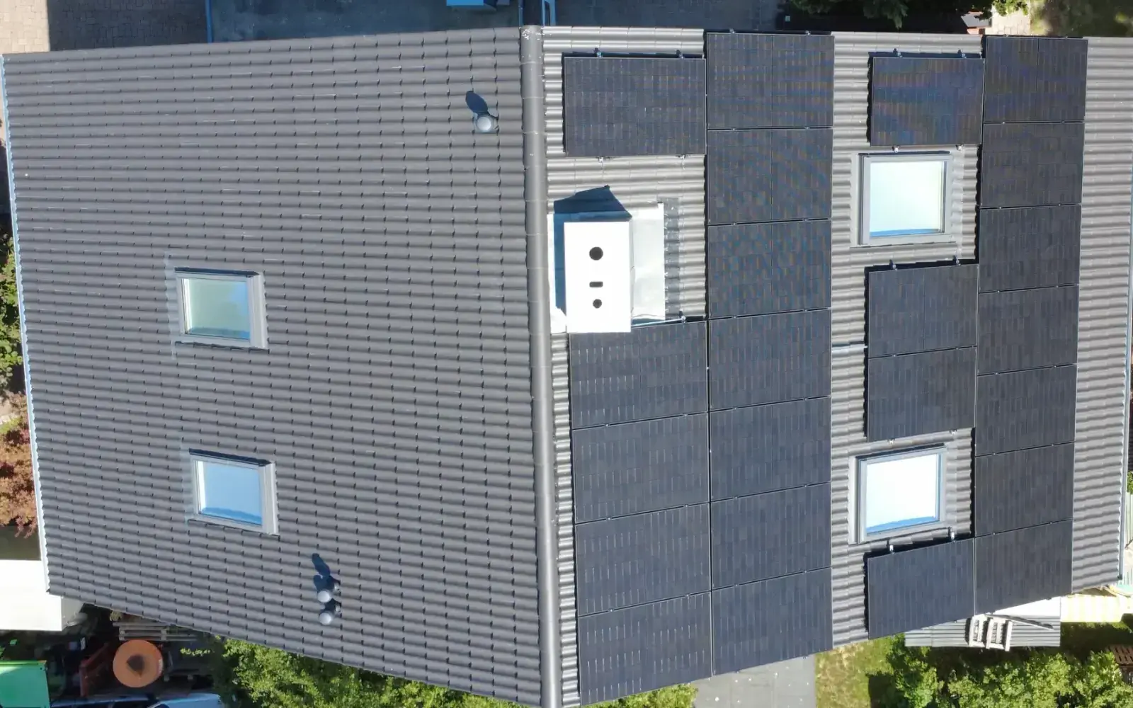 Dasselbe Dach von oben danach: neue dunkle Dachsteine, schwarze Photovoltaikmodule und neue Dachfenster